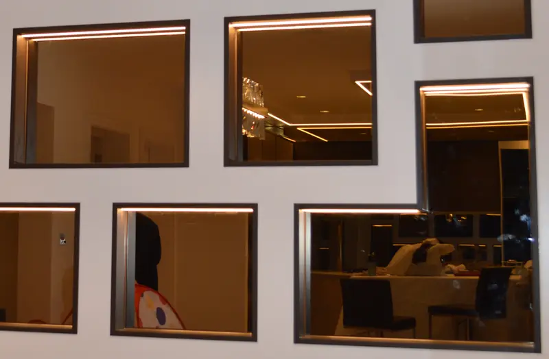 Recessed bronze-tone mirror panels with LED lighting in a geometric arrangement