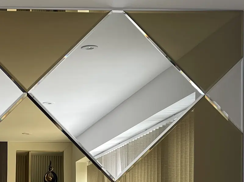 Diamond-pattern bevelled mirror wall alternating bronze and silver panels